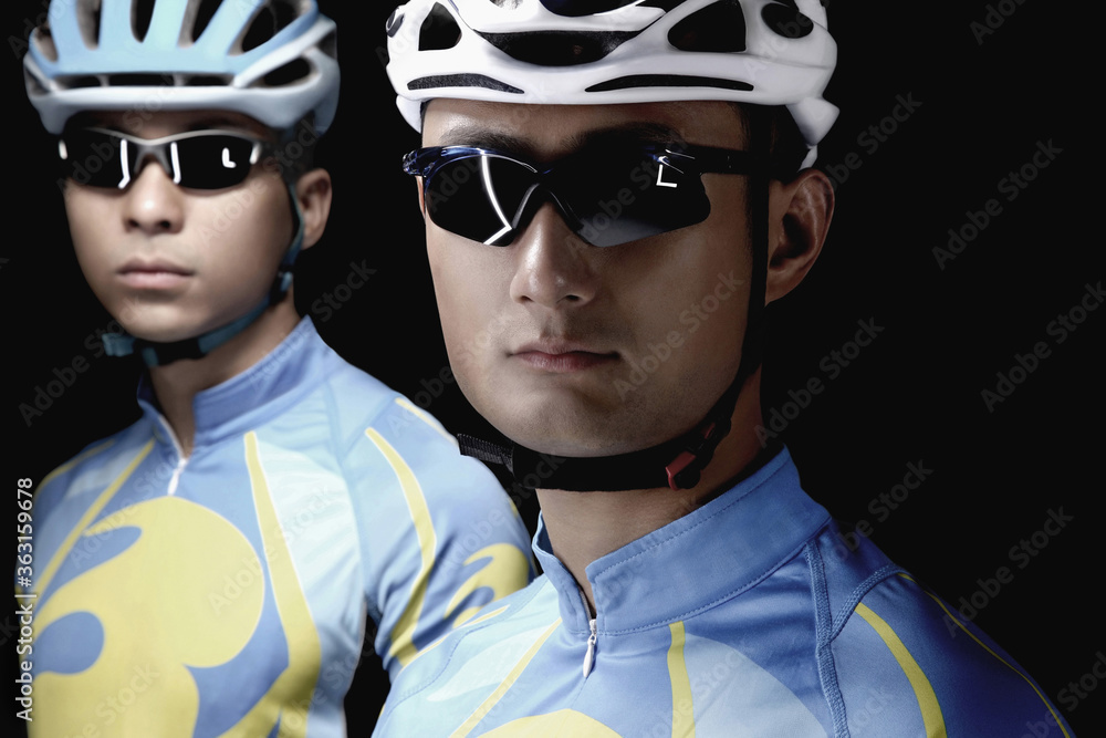 Male cyclists in cycling helmets and sunglasses Male cyclists in cycling helmets and sunglasses