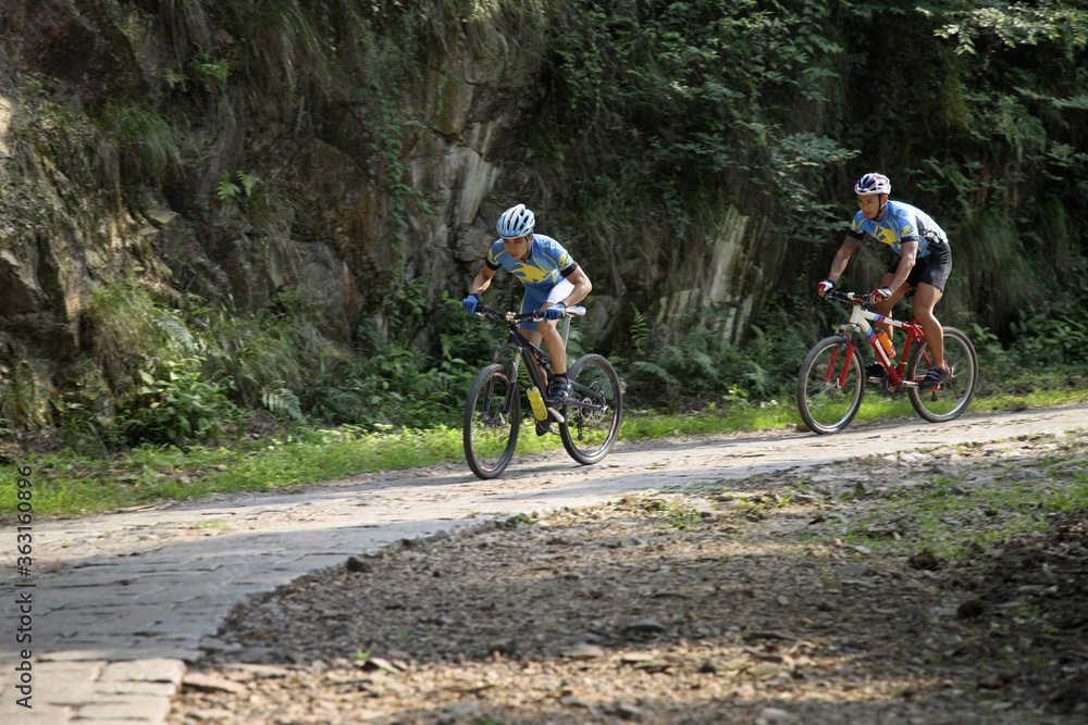 Naklejka premium Male cyclists riding on the mountain