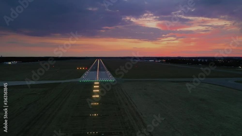 Aerial view on empty airport runaway with markings for landings and all navigation lights (ILS Cat II) on at the colorful sunset, clear for airplane landing or taking off in Wroclaw airport photo