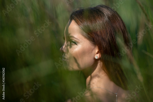 Beautiful young woman posing in a grass field