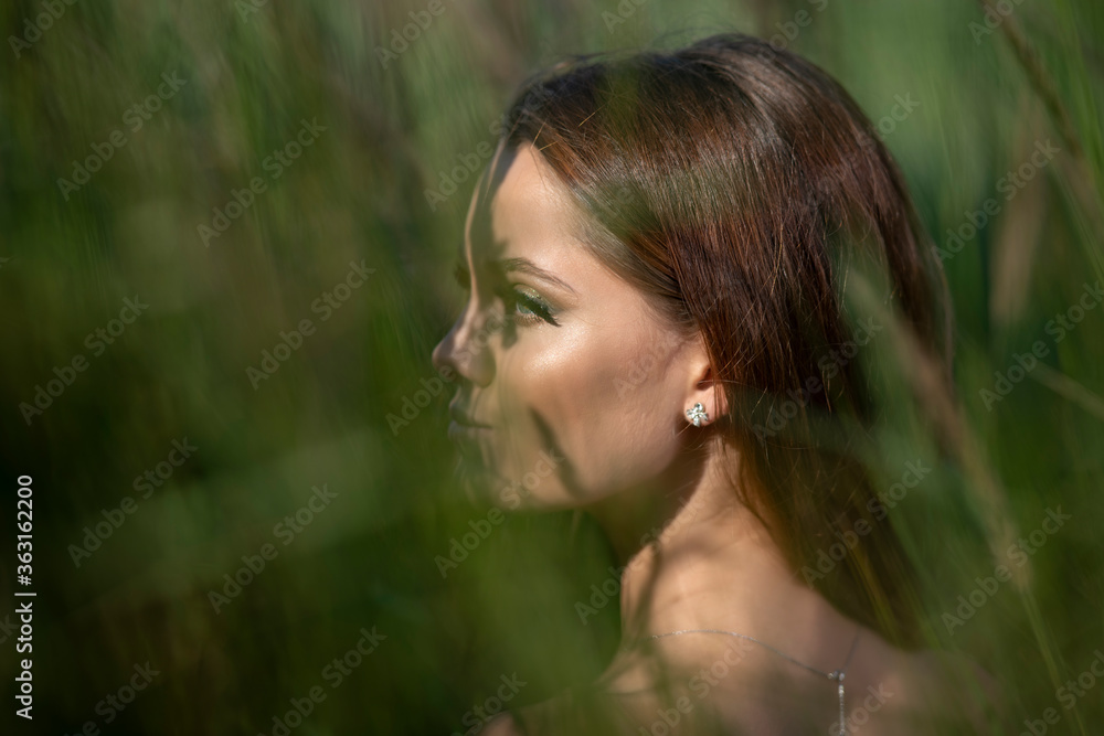 Beautiful young woman posing in a grass field Beautiful young woman posing in a grass field