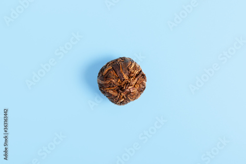 Chinese puer tea pressed in the shape of a ball on a blue background. tea shop or tea ceremony concept. Health drink concept. minimalism, copy space. photo