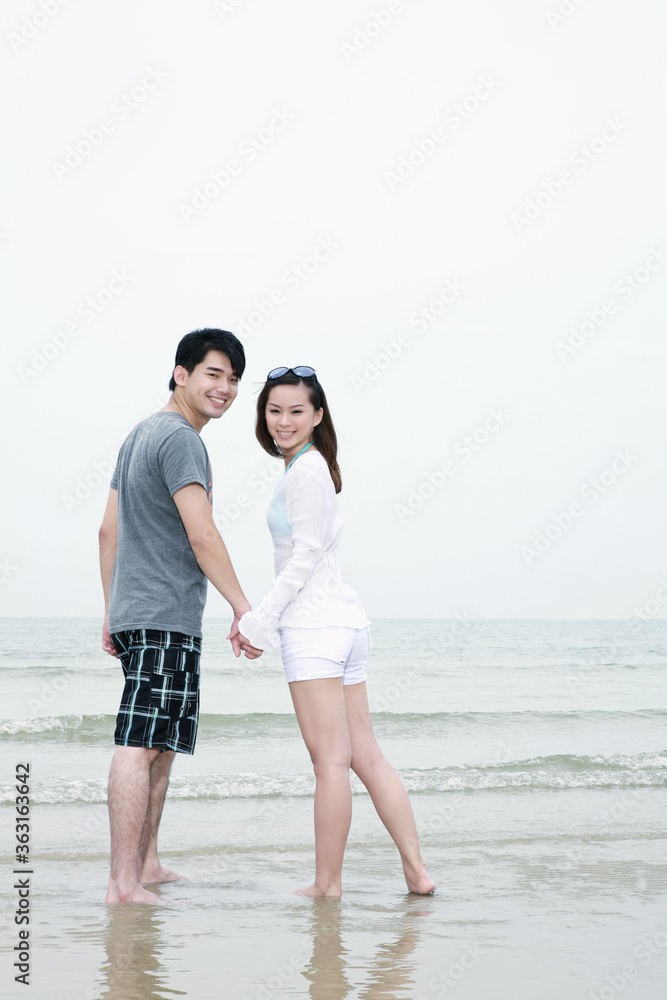 Man and woman holding hands and walking on the beach Man and woman holding hands and walking on the beach