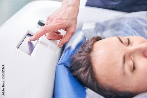 Cosmetologist controlling the settings of floating device