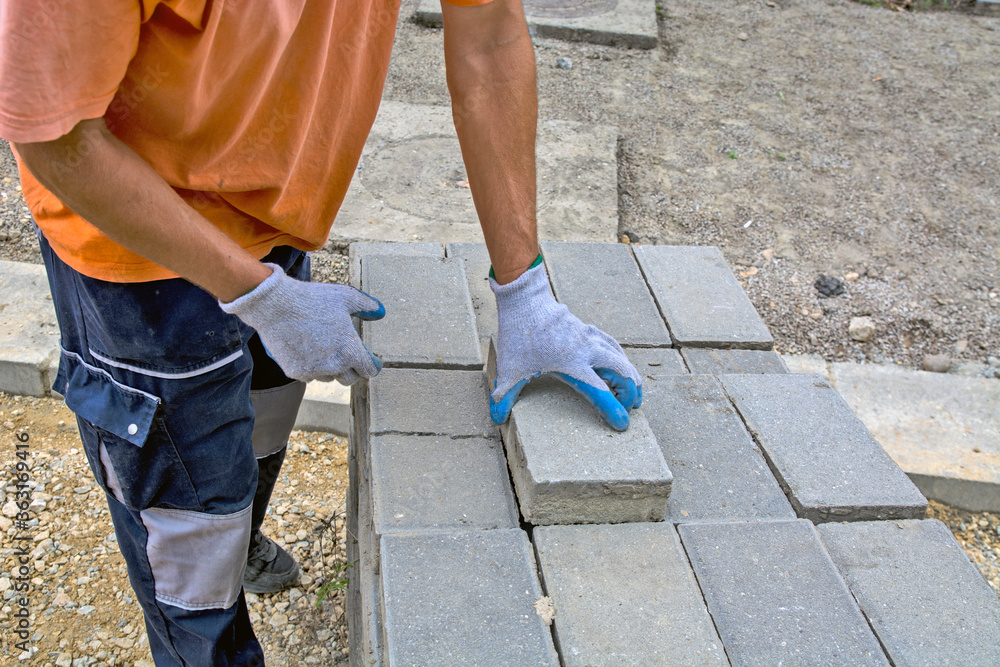 Laying concrete bricks for the sidewalk