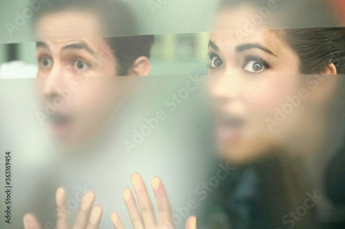 Slika na platnu Business people in shock while peeping through a glass window