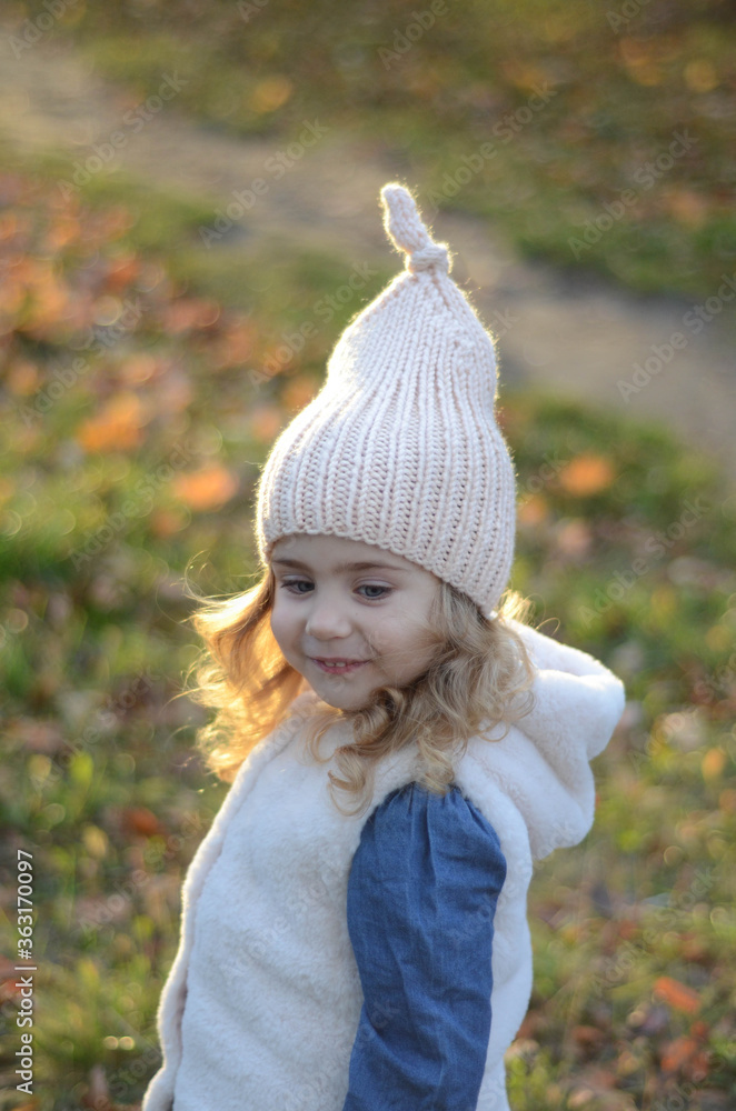 Picture of a blonde toddler girl in the funny knitted hat Picture of a blonde toddler girl in the funny knitted hat