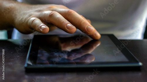 Close-up image of busy hands using computer. Man making online shopping with his tablet. Front portrait of man using smart phone. Man's hands as he is sitting on a sofa and using a mobile. .