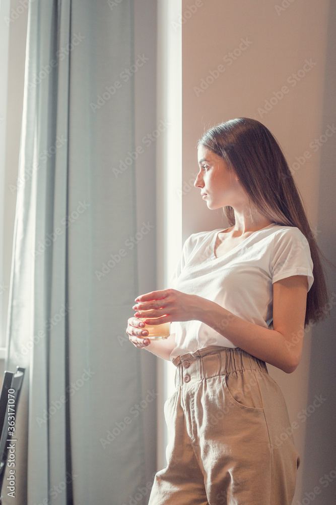 Beautiful woman drinking morning tea behind window Beautiful woman drinking morning tea behind window