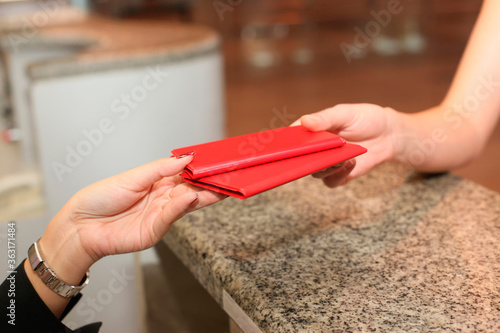 Wallpaper Mural Airline check-in attendant returning passports to woman at the airport check-in counter Torontodigital.ca