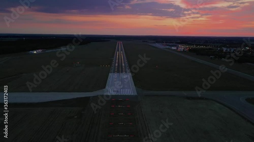 Empty airport runaway with braking and maneuvering marks, designation 29 and all navigation lights on at the colorful sunset, clear for airplane landing or taking off in Wroclaw  airport photo