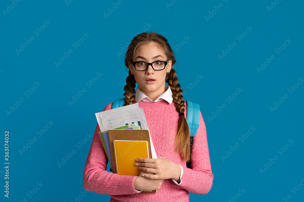 School, college and university concept. Surprised, scared girl holding notebooks and graphics School, college and university concept. Surprised, scared girl holding notebooks and graphics