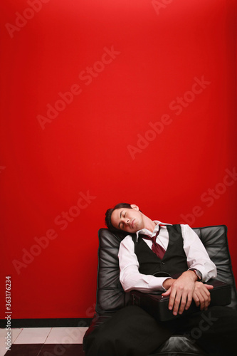 Businessman with briefcase sleeping on sofa