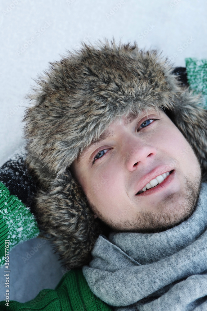 Man with fur hat lying on snow Man with fur hat lying on snow