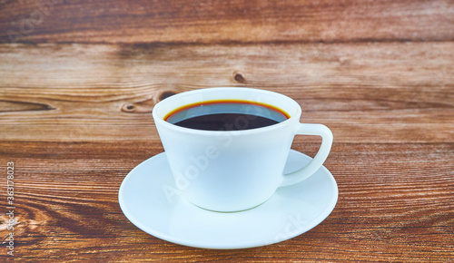 Hot black coffee on wooden background.