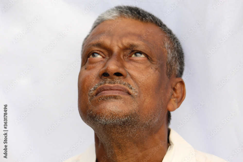 Closed mouth and beard of a senior Indian man looking up, white background. Old Indian man with black and white hair. Closed mouth and beard of a senior Indian man looking up, white background. Old Indian man with black and white hair.