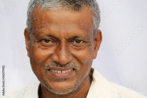 Smiling Indian senior man face portrait on white background.