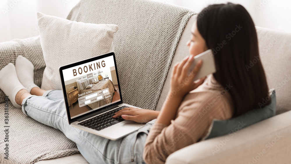 Girl booking hotel online, talking on phone with reservation team Girl booking hotel online, talking on phone with reservation team