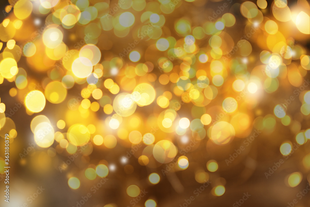 Blurred view of gold lights as abstract background, bokeh effect
