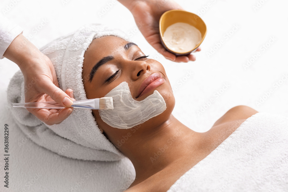 Top view of beauty therapist applying face mask - obrazy, fototapety, plakaty 