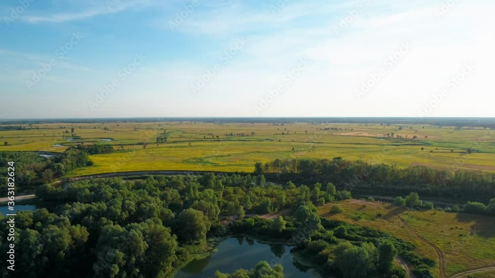 Aerial view of a beautiful landscape: trees forest field river sky nature. 4K slow motion drone footage Aerial view of a beautiful landscape: trees forest field river sky nature. 4K slow motion drone footage