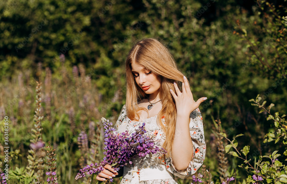 Cute blonde enjoys a lupine bouquet in the field. Cute blonde enjoys a lupine bouquet in the field.