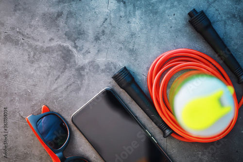 Jump rope. Physical education. Sports exercise equipment. Rope exercises routine. Pink jump rope phone with a stopwatch and water on the table.