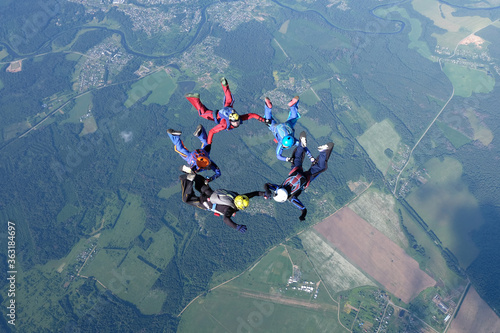Skydiving. Skydivers are training and flying in the sky.