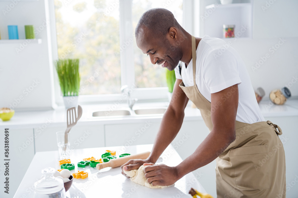 Profile side view portrait of nice cheerful guy confectioner making fresh bread pie pide doughing flour learning spending time vacation weekend quarantine in modern light white interior house kitchen Profile side view portrait of nice cheerful guy confectioner making fresh bread pie pide doughing flour learning spending time vacation weekend quarantine in modern light white interior house kitchen