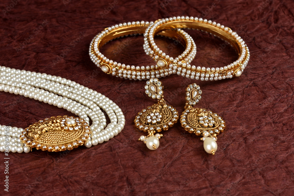 Obraz premium Pearl Jewelry on a textured background, Pearl bracelet, pearl necklace, pearl earrings, Style, fashion and design of jewelry. indian traditional jewellery,jewelry background