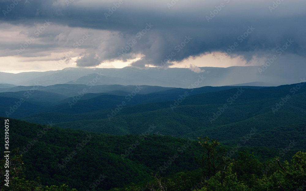 Rain over forest mountains. Misty mountain landscape hills at rainy day.