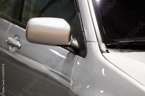 Exterior mirror of a silver sports car.