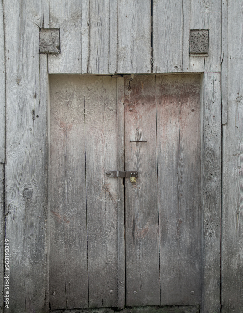 Old barn doors with a lock made from rustic weathered wood. Old barn doors with a lock made from rustic weathered wood.