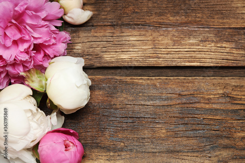 Beautiful peonies on wooden background, flat lay. Space for text