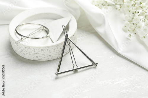 Beautiful silver hair clips and flowers on white table