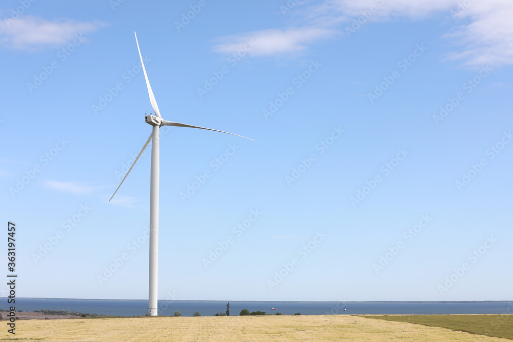 Fototapeta premium Beautiful view of field with wind turbine. Alternative energy source