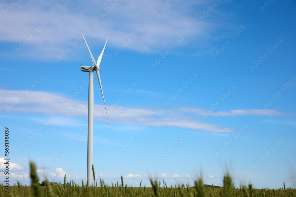 Beautiful view of field with wind turbine. Alternative energy source Beautiful view of field with wind turbine. Alternative energy source