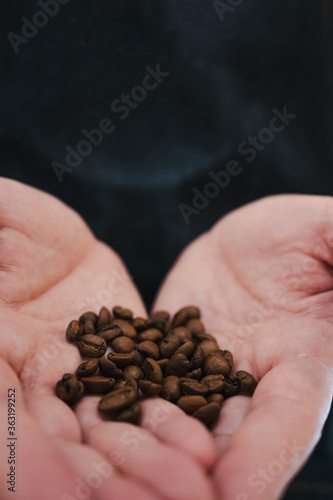 barista irreconocible enseñando granos de café en la mano