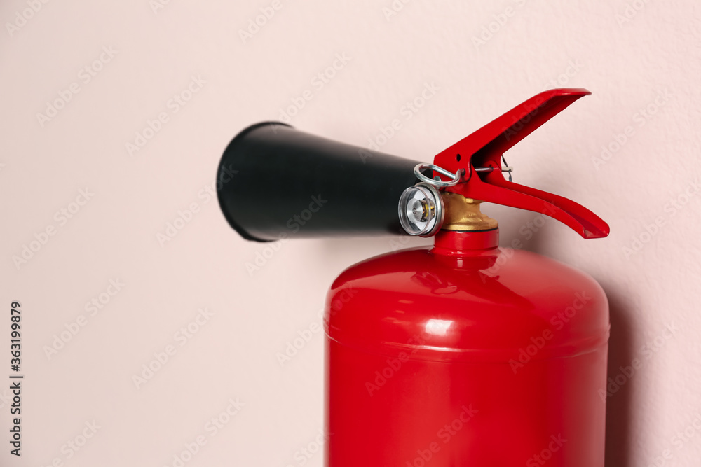 Obraz premium Fire extinguisher on pink background, closeup view