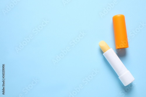 Hygienic lipstick on light blue background, flat lay. Space for text
