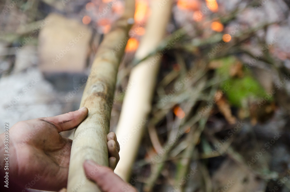 Close up hands and wood of flames on charred wood, in a nature Close up hands and wood of flames on charred wood, in a nature