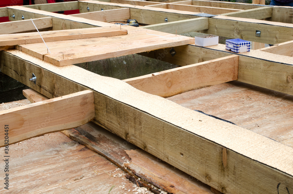 building a porch, balcony floor with brown wooden planks. the floor and some tools including a drilling machine. building a porch, balcony floor with brown wooden planks. the floor and some tools including a drilling machine.