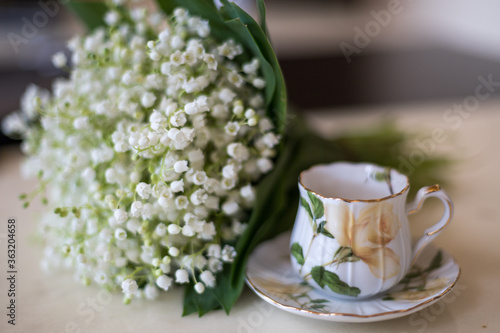 a cup of coffee with lilies of the valley