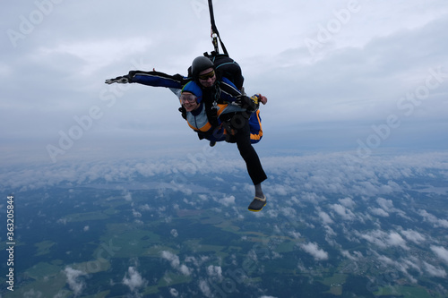 Skydiving. Tandem jump in the cloudy sky.