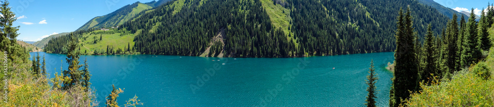 Beautiful view to Kolsai or Saty lake with mountains background. Summer vacation concept. Scenic travel background. Travel in Kazakhstan concept.