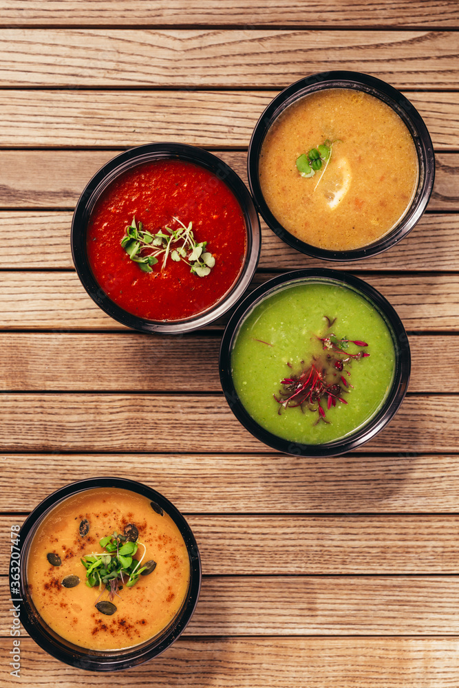 flat lay of cream vegetable soups on wooden table flat lay of cream vegetable soups on wooden table