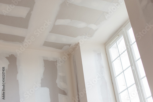 unfinished plasterboard, during reconstruction, closeup wall and ceiling