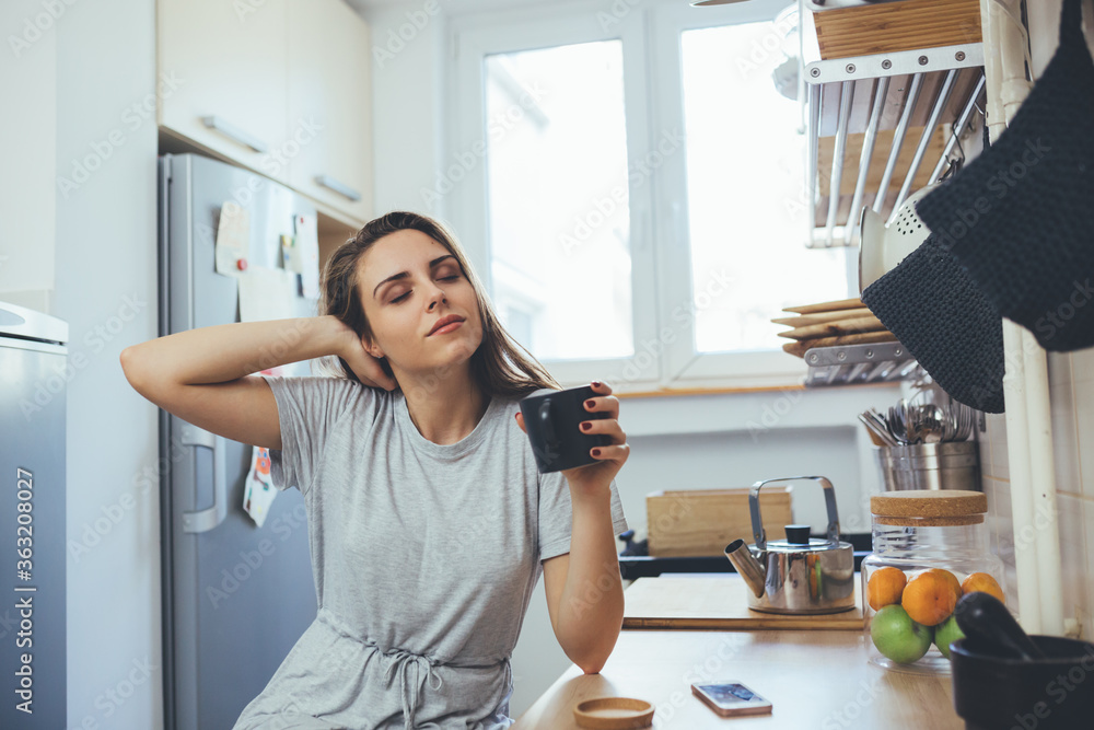 young woman drinking morning coffee in her kitchen young woman drinking morning coffee in her kitchen