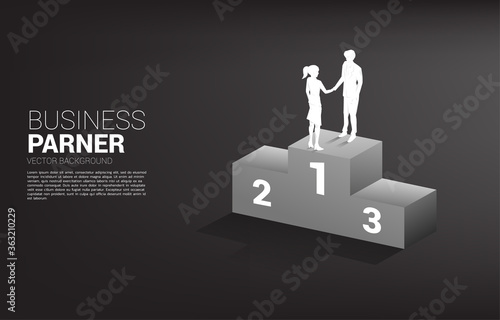 Silhouette of businessman and businesswoman handshake on top of podium. Concept of team work partnership and cooperation.