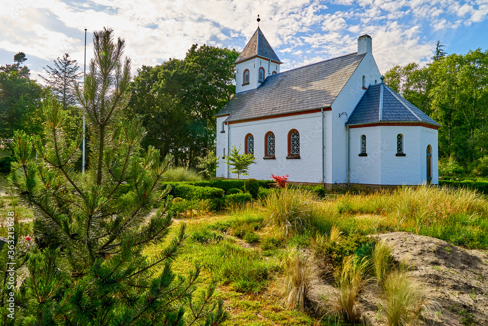 Oksbøl, Denmark - June 21, 2020: the church Børsmose Kirke in scenic late afternoon sunlight with vivid sky